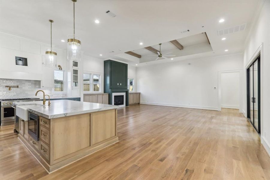 A look into the family room from the hall between the kitchen and dining room illustrates the open floorplan living provided in this home.