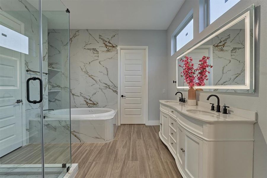 First floor primary bath is a show stopper with the curved front vanity, seamless glass shower and corner soaking tub.