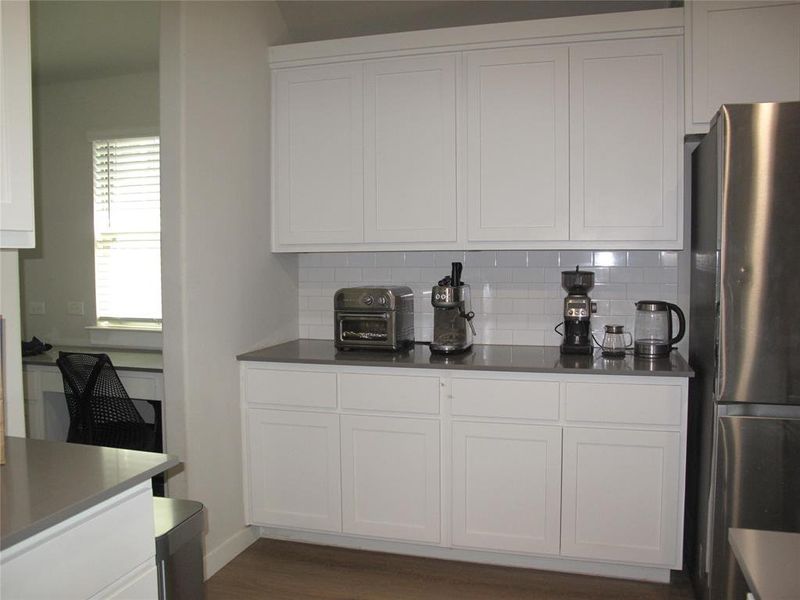 Kitchen with white cabinets and stainless steel refrigerator