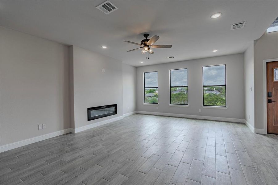 Unfurnished living room with light hardwood / wood-style floors and ceiling fan