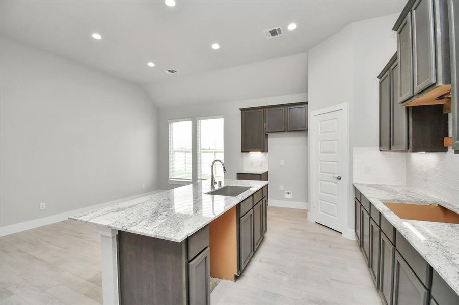 This generously spacious layout boasts a massive granite island, high ceilings, soft-close cabinets, granite countertops,  and recessed lighting.