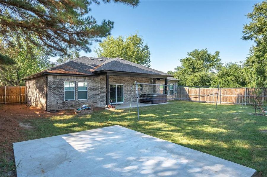 Back of house with a lawn and a patio area