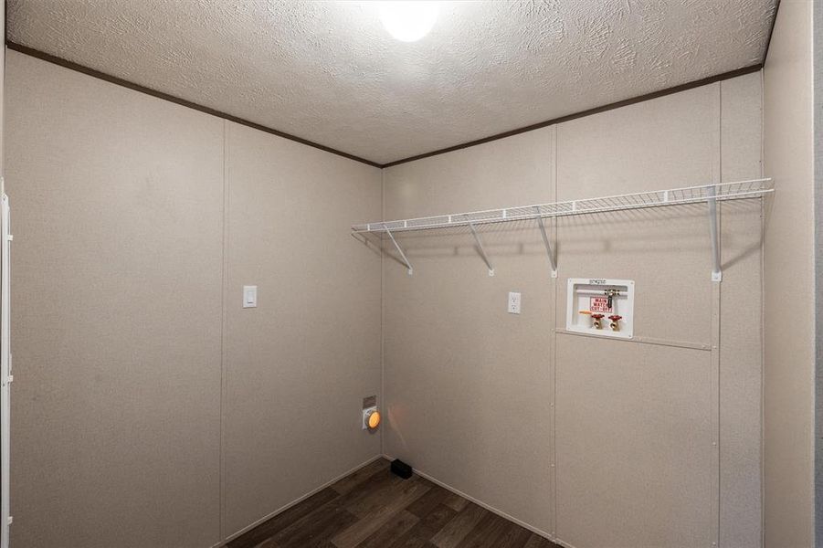 Washroom featuring washer hookup, dark hardwood / wood-style flooring, and a textured ceiling