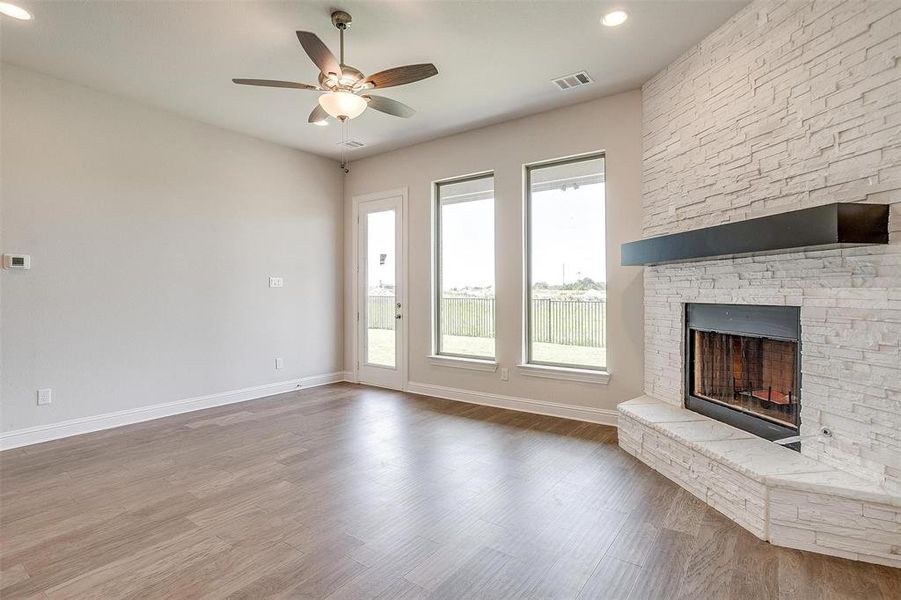 Unfurnished living room with ceiling fan, a fireplace, and hardwood / wood-style floors