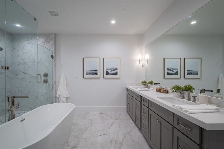 Bathroom featuring vanity and separate shower and tub