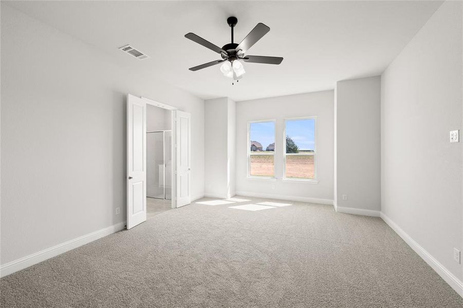 Unfurnished bedroom with ceiling fan and light colored carpet