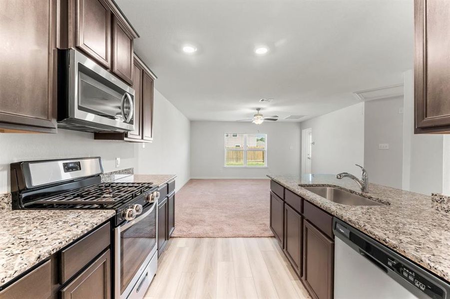 In addition to the granite counter tops, the Kitchen boasts clean recessed lighting, a large closet pantry, and a deep single bowl sink with pull-out sprayer for easy clean-up.