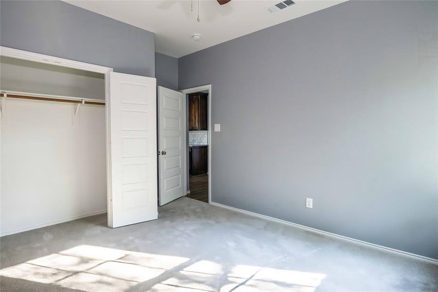 Unfurnished bedroom featuring a closet, carpet flooring, and ceiling fan