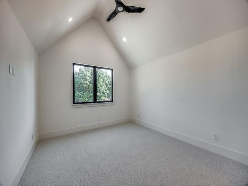 Carpeted spare room with lofted ceiling