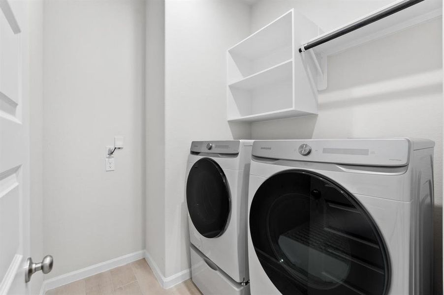 The dedicated laundry room includes a washer and dryer, offering convenience and efficiency for household chores.