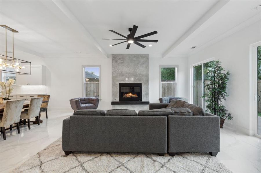 Living room featuring ceiling fan with notable chandelier and a fireplace