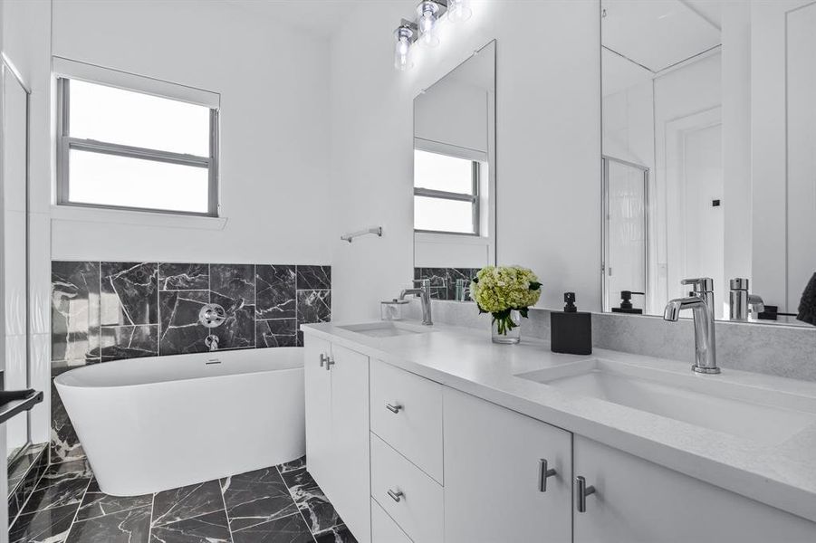 Primary Bathroom featuring a tub to relax in and vanity