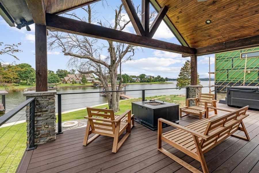 Deck with a water view and an outdoor living space with a fire pit