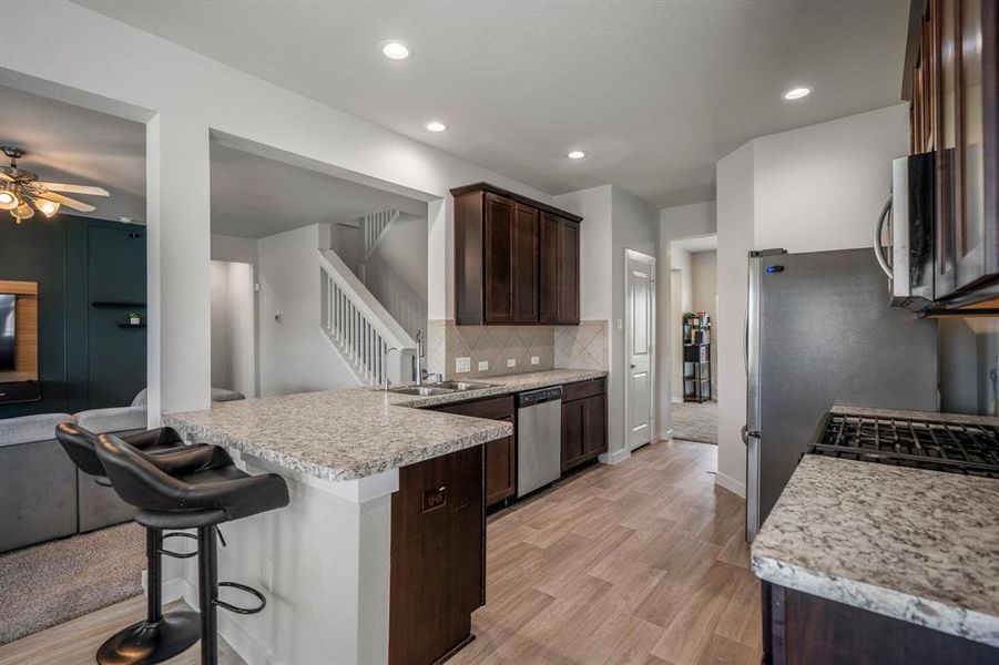 You will love the details of this kitchen! It features wood cabinets, a large pantry, granite countertops, recessed lighting, wood like flooring, and stainless steel appliances!