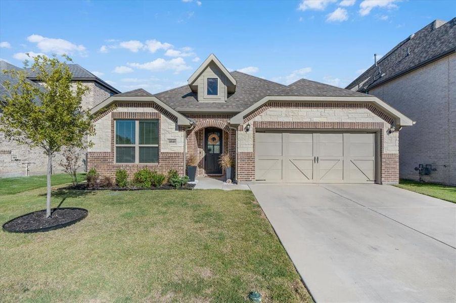 View of front of home with a garage and a front lawn