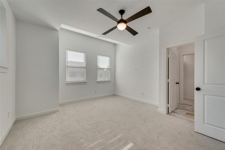 Spare room featuring light carpet and ceiling fan