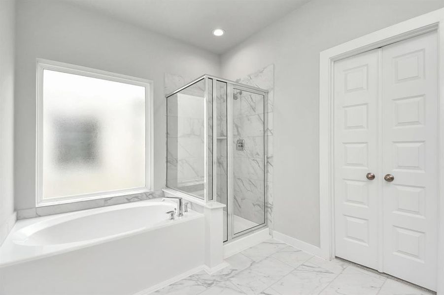 Enjoy a walk-in shower with tile surround, a separate garden tub with custom detailing,