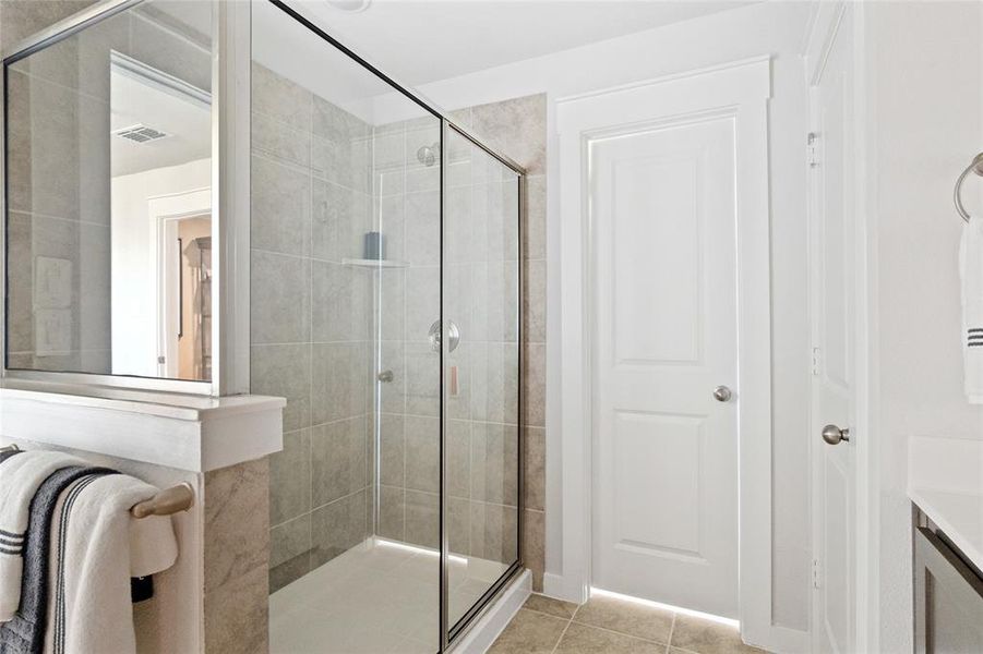 Bathroom with tile patterned flooring, vanity, and a shower with shower door