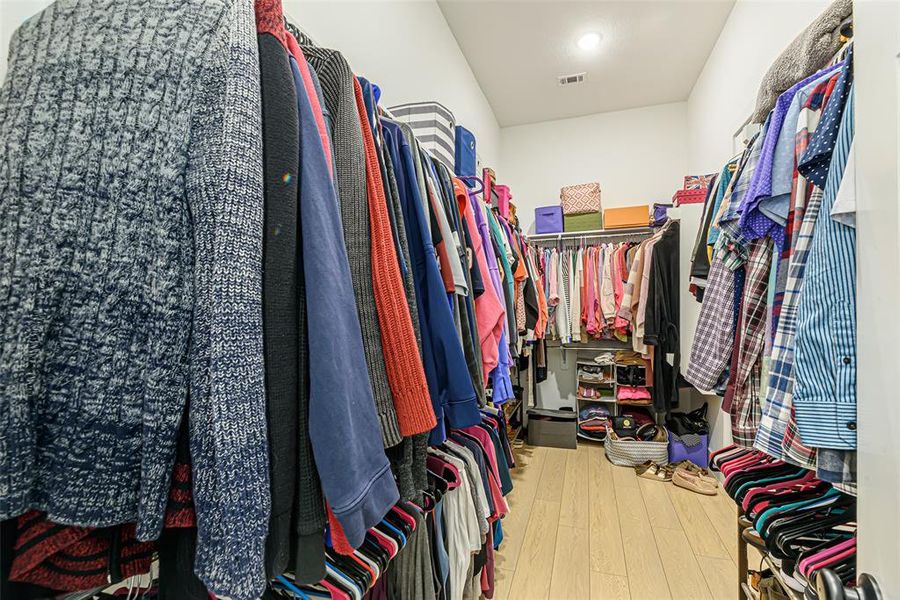 Primary walk-in closet with access to the back hallway.