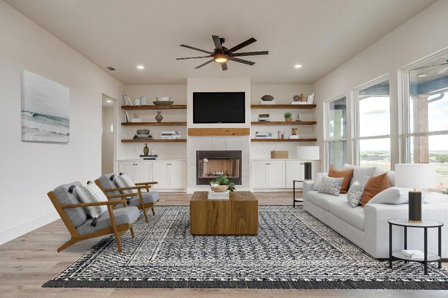 Living room featuring ceiling fan, a fireplace, and light hardwood / wood-style floors