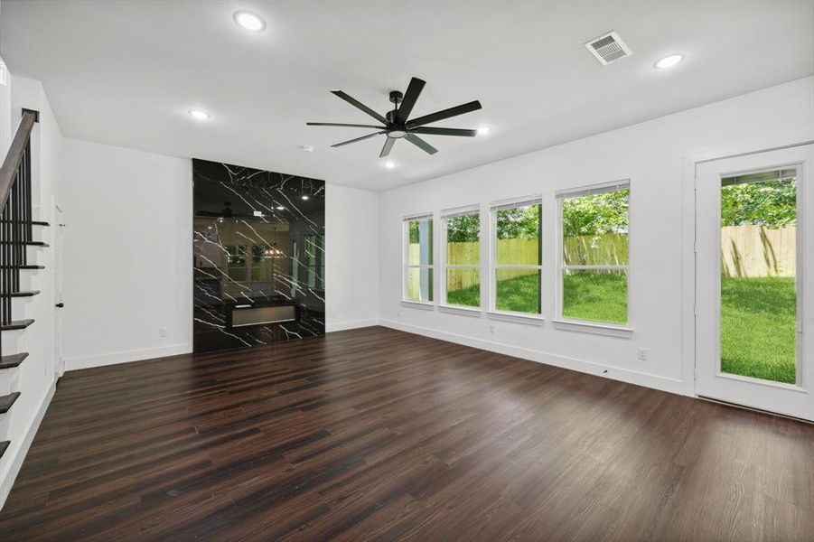 Unfurnished living room featuring dark hardwood / wood-style floors and ceiling fan