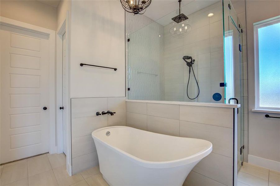 Bathroom featuring shower with separate bathtub, tile walls, and tile floors