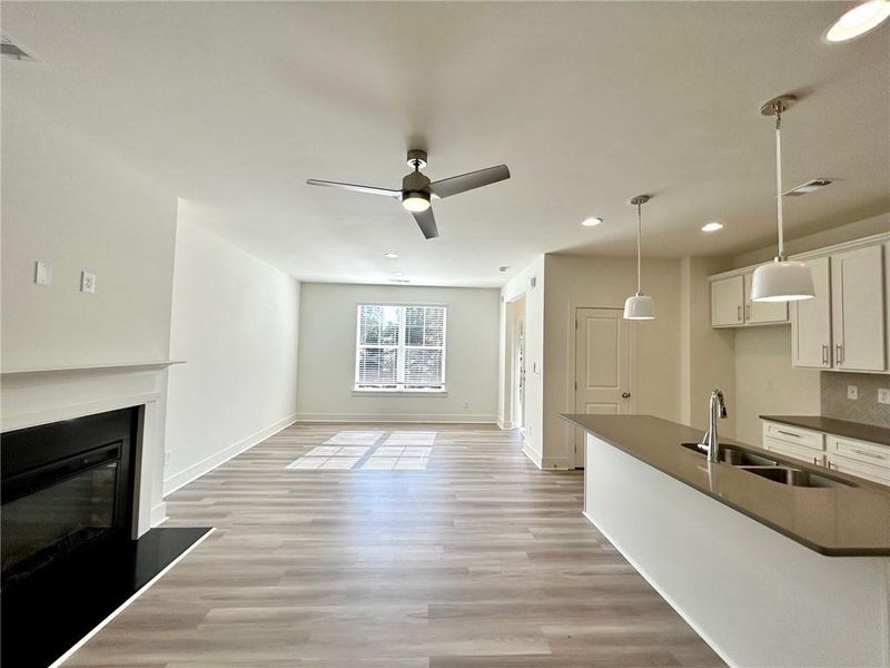 Kitchen featuring hanging light fixtures, sink, ceiling fan, and light hardwood / wood-style flooring