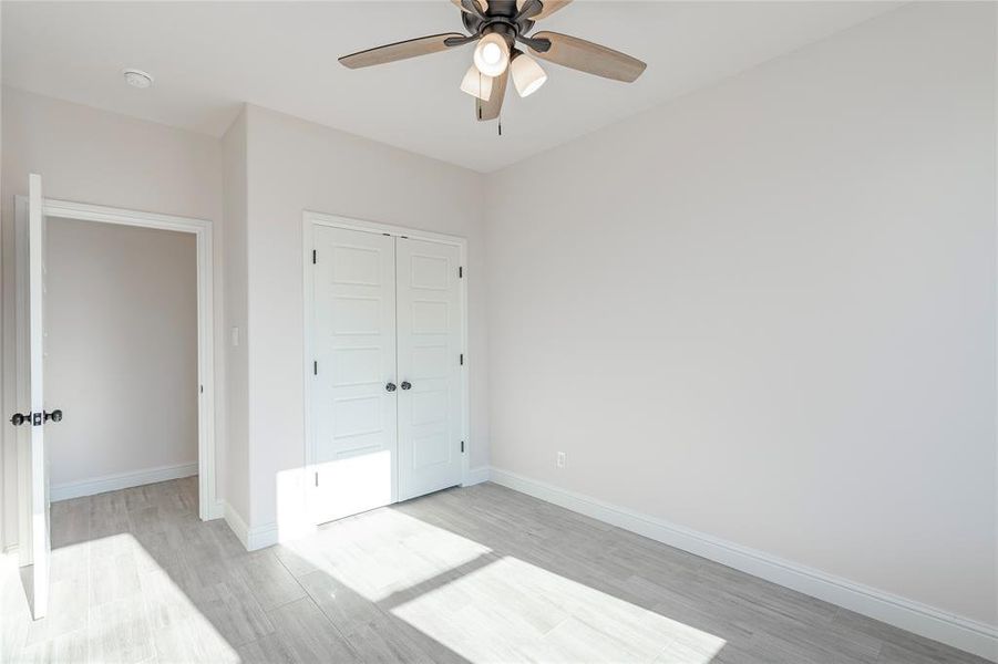 Unfurnished bedroom with a closet, ceiling fan, and light hardwood / wood-style flooring