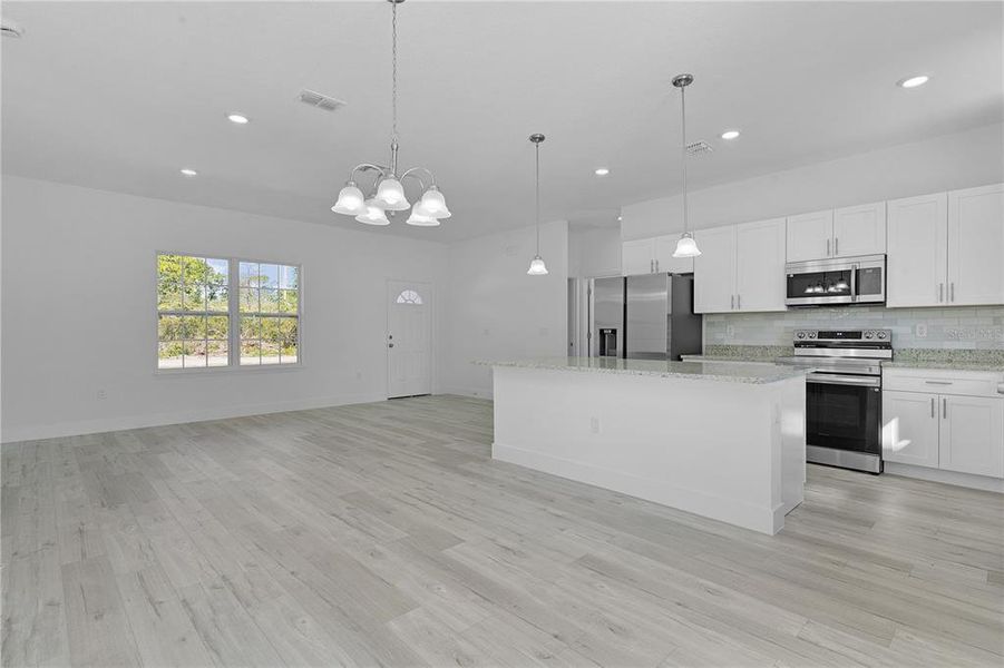 From dining area, with kitchen on the right, looking toward the front of the home and living area