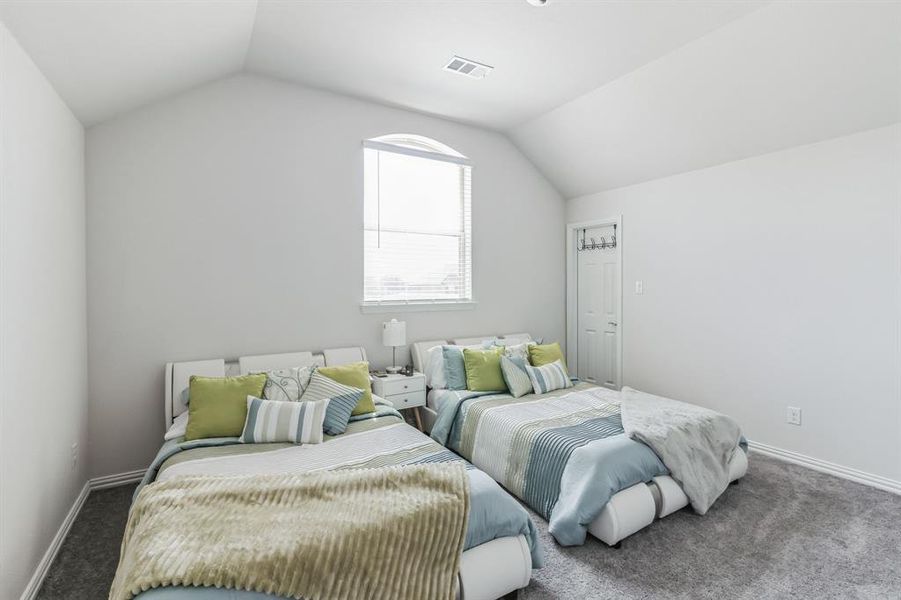 Carpeted bedroom with lofted ceiling