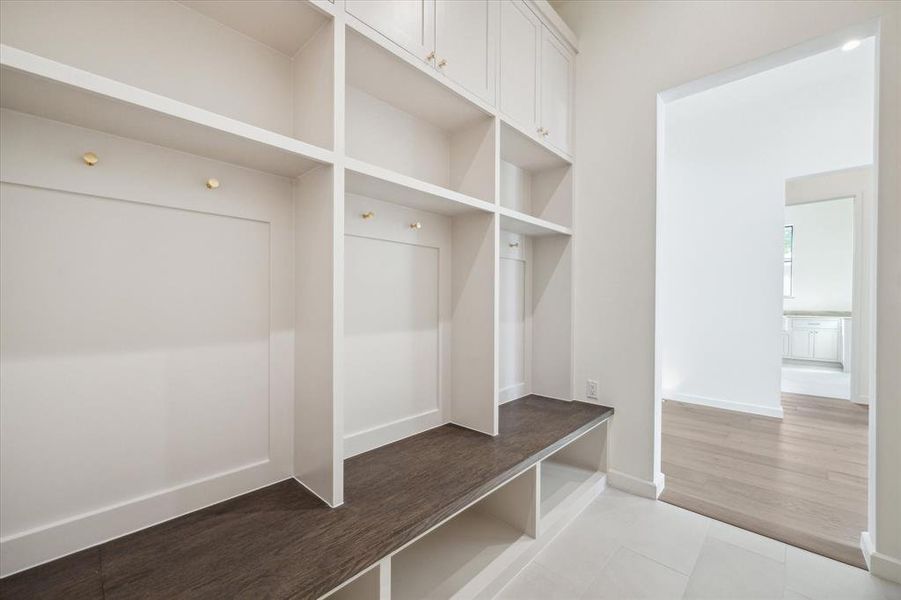 Custom built-in cabinetry in the mudroom provides organized storage space for coats, bags, and shoes, ensuring a clutter-free entrance from the garage.