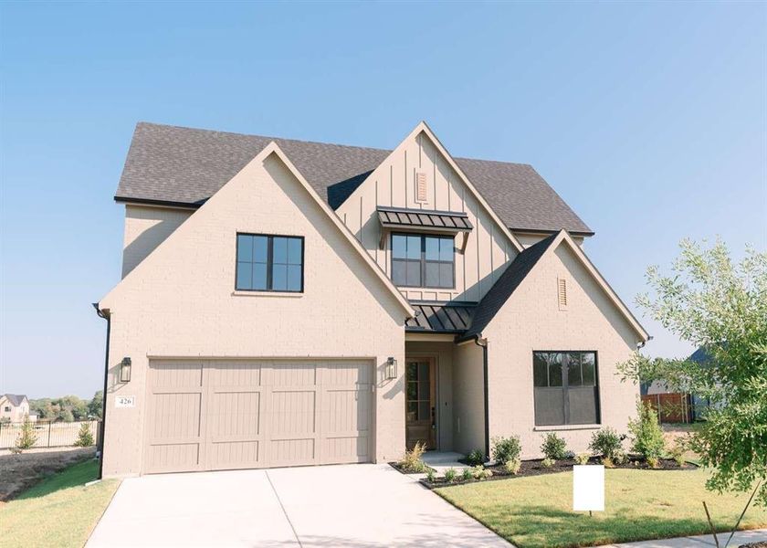 Modern farmhouse style home featuring a front yard and a garage