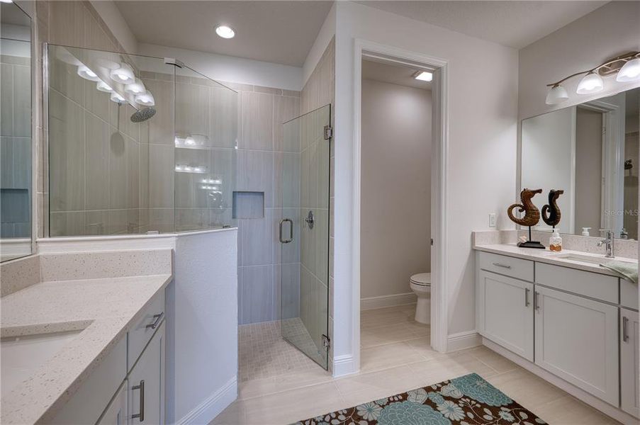 Primary Bathroom: Lovely tile shower, split vanity areas and a private water closet.