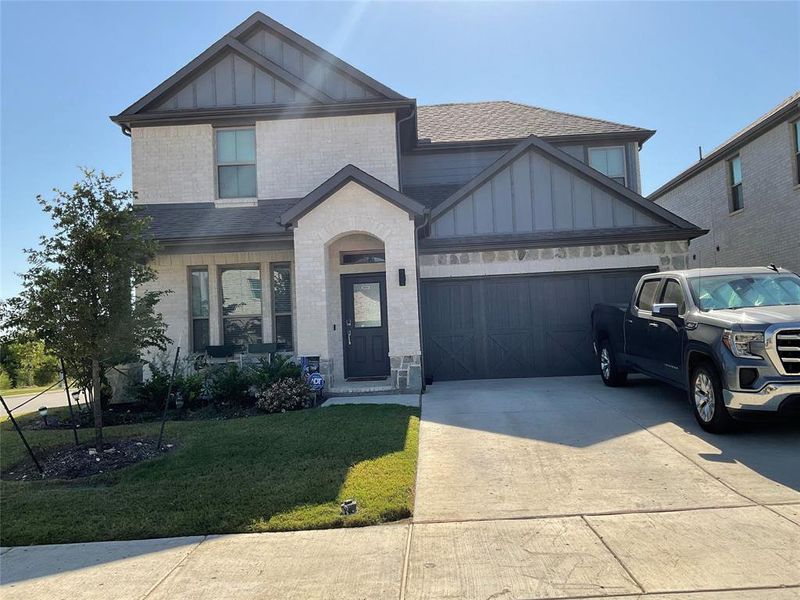 View of front of property with a garage and a front yard