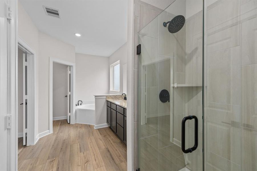 The primary bath features large walk-in shower, corner garden tub, and spacious vanity.