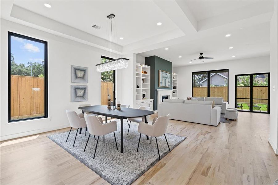 Entry hall leads to the dining room with a contemporary light fixture, high ceilings and LED lighting, adjacent to the inviting living room.