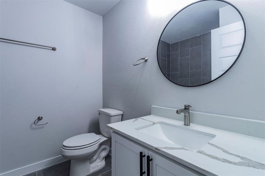 Bathroom with tile patterned floors, vanity, and toilet