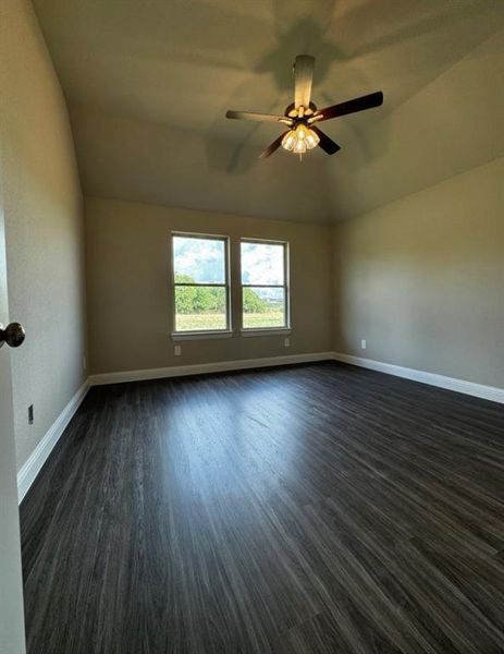 Unfurnished room with ceiling fan, vaulted ceiling, and dark hardwood / wood-style flooring