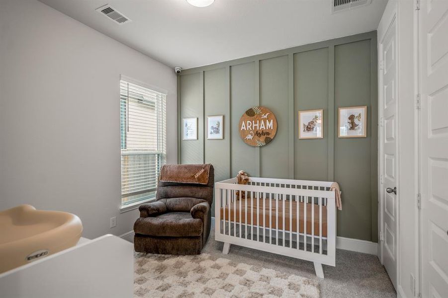 The final secondary bedroom features a custom accent wall, two closets, plush carpet, and bright natural light.