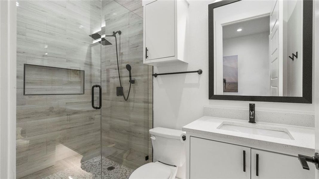 Bathroom featuring vanity, toilet, and walk in shower