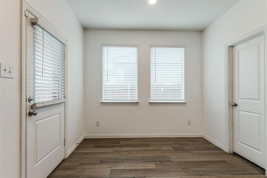 Doorway featuring a wealth of natural light and dark wood-type flooring