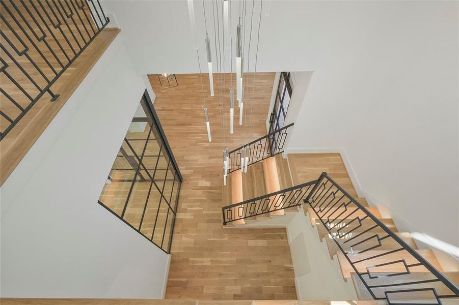 View from the top of the stairs. The long pendent chandelier Accents the two story entry.