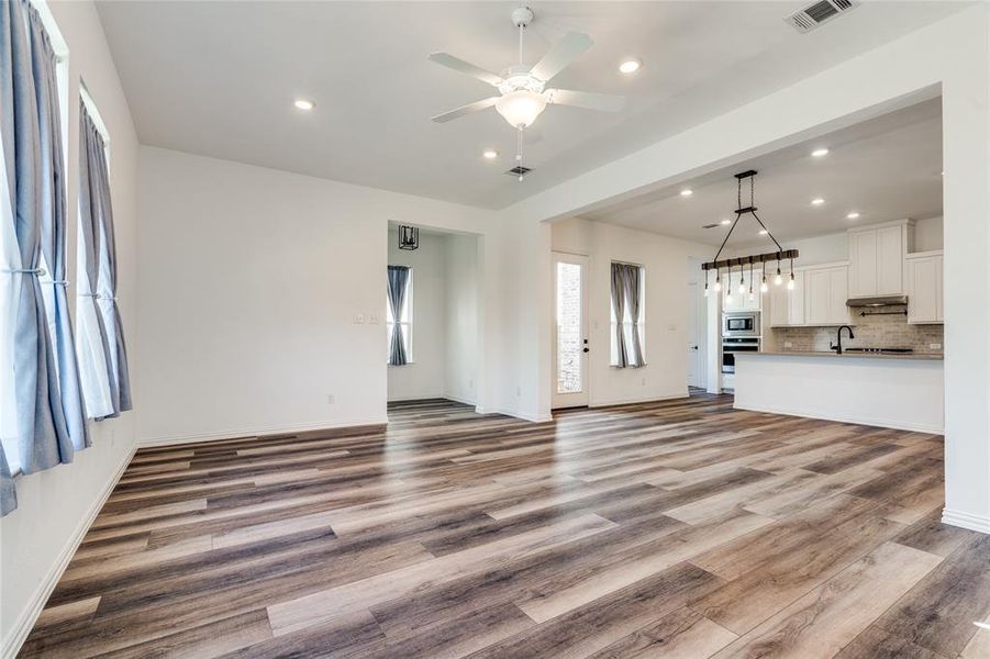 Unfurnished living room with light wood-type flooring, ceiling fan, and sink