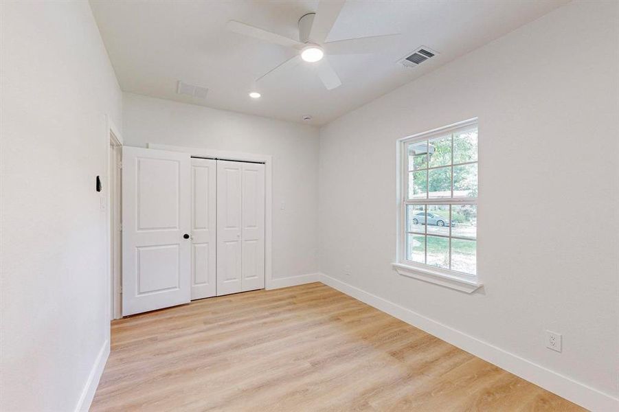 Bedroom 2 with light hardwood / wood-style floors, a closet, and ceiling fan