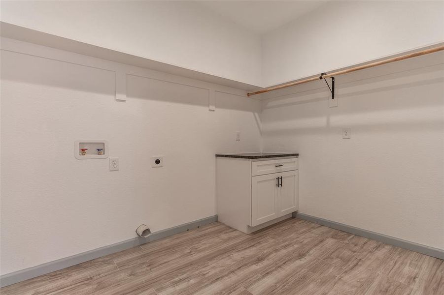 Laundry room with washer hookup, electric dryer hookup, and light wood-type flooring