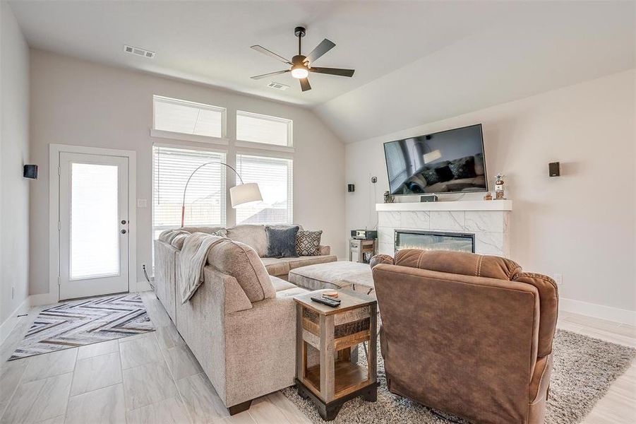 Living room featuring ceiling fan, lofted ceiling, surround sound wiring, floor to ceiling windows