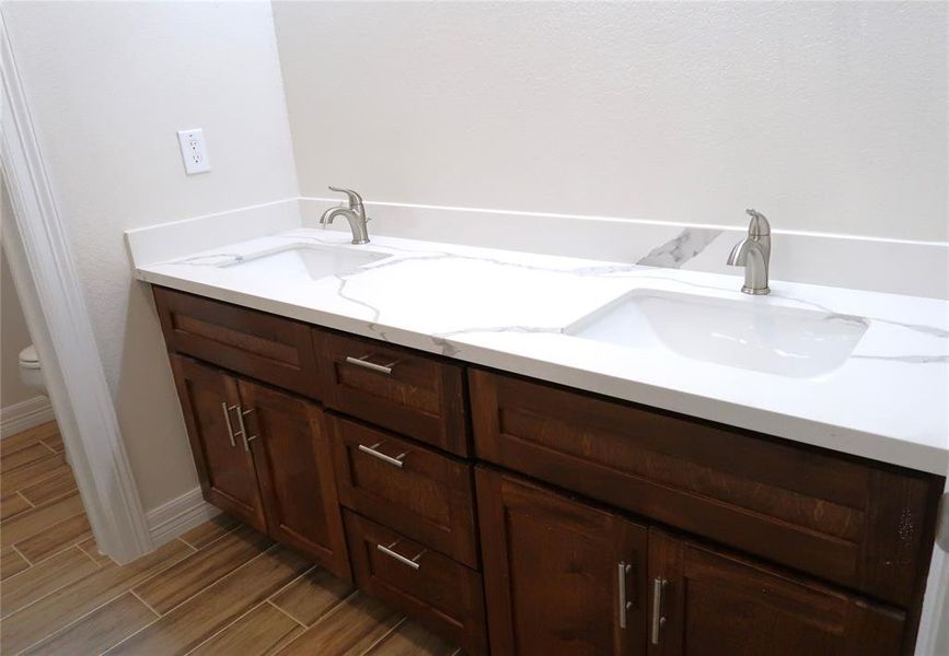 Double sink custom built vanity with quartz countertops for ensuite bathroom.