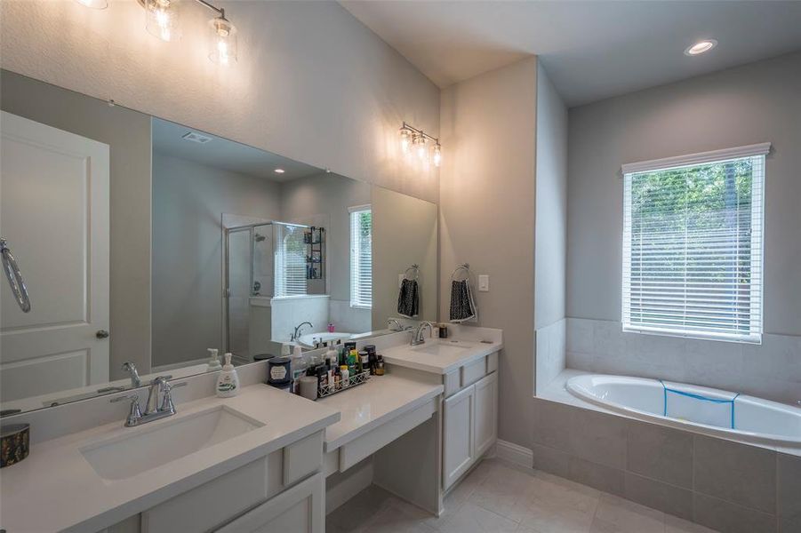 The primary ensuite features his and her sinks with a makeup vanity in between.