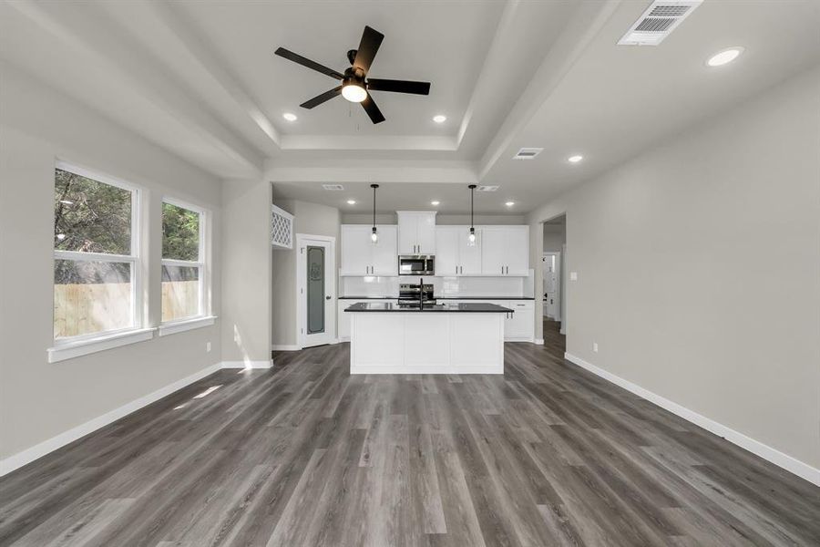 Kitchen featuring hanging light fixtures, dark hardwood / wood-style floors, white cabinetry, and appliances with stainless steel finishes