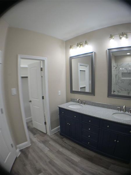 Bathroom featuring hardwood / wood-style floors, a shower, and vanity